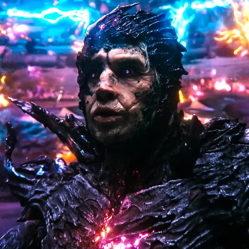 A person clad in dark, jagged, alien-like armor is surrounded by KM Effects—glowing, colorful energy streaks—in a futuristic or supernatural setting. Their eyes emit a vivid purple glow.