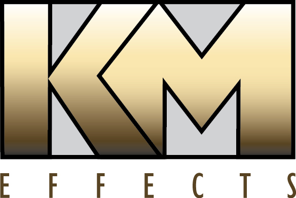 Logo with large gold gradient letters KM centered inside a black rectangle. Below, the word EFFECTS appears in spaced-out, uppercase gold letters. The background features a white and gray palette, drawing attention to the logos location.