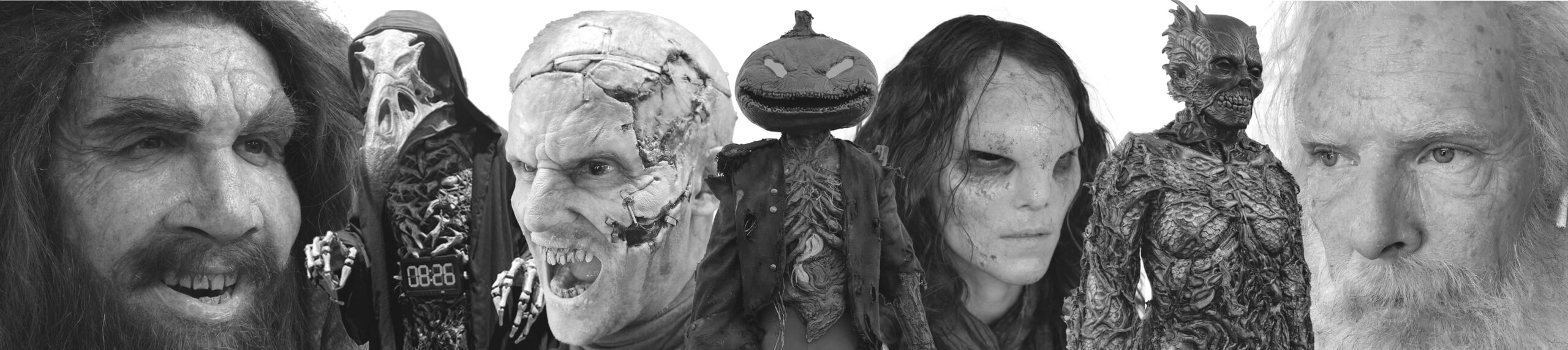 A lineup of seven people in elaborate monster and creature makeup by KM Effects, featuring skull-like faces, gnarled features, a pumpkin-headed figure, and a mossy tree-like being, all captured in striking black and white.